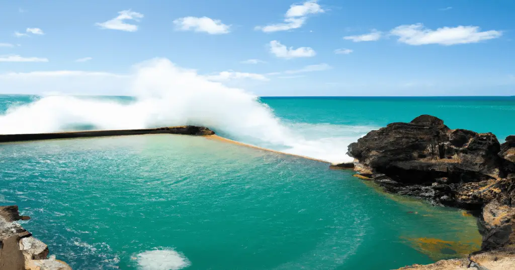 Black Point Saltwater Pool in Hawaii with turqoise waters and waves crashing