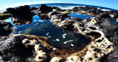Fish eye lens shot of volcanic tide pool and curved horizon