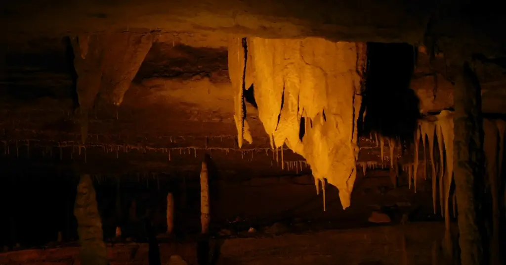 Cave in the Great Smoky Mountains with Stalactites of various shapes illuminted by warm yellow light