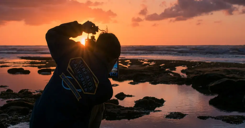 Silhouette of photographer taking pictures of the Terra Mar tide pools during sunset