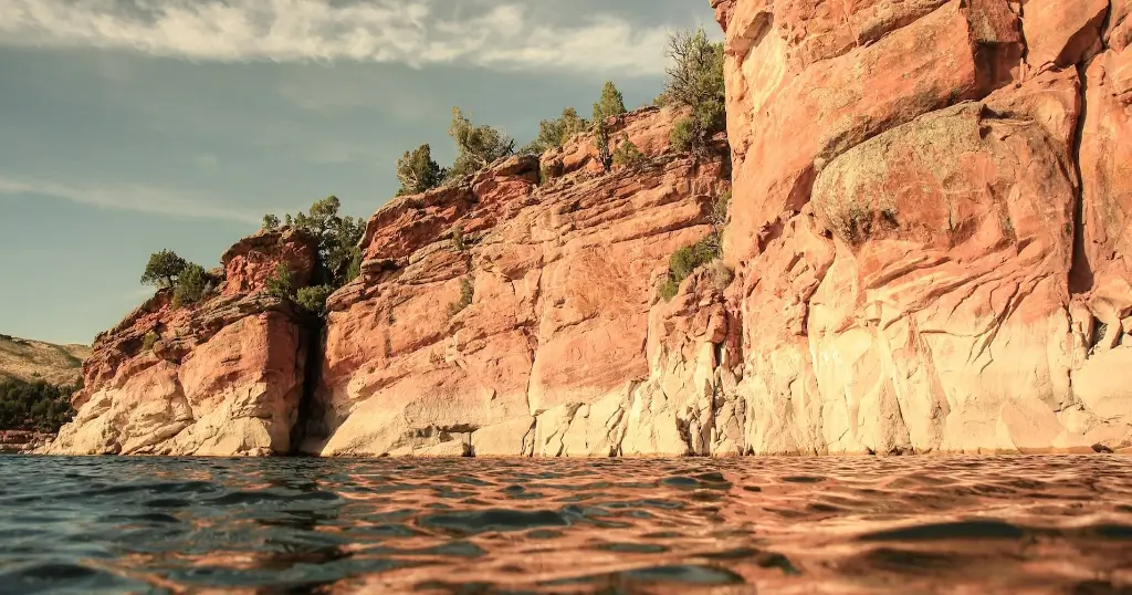Red, rocky cliffs overtowering a calm lake in Texas